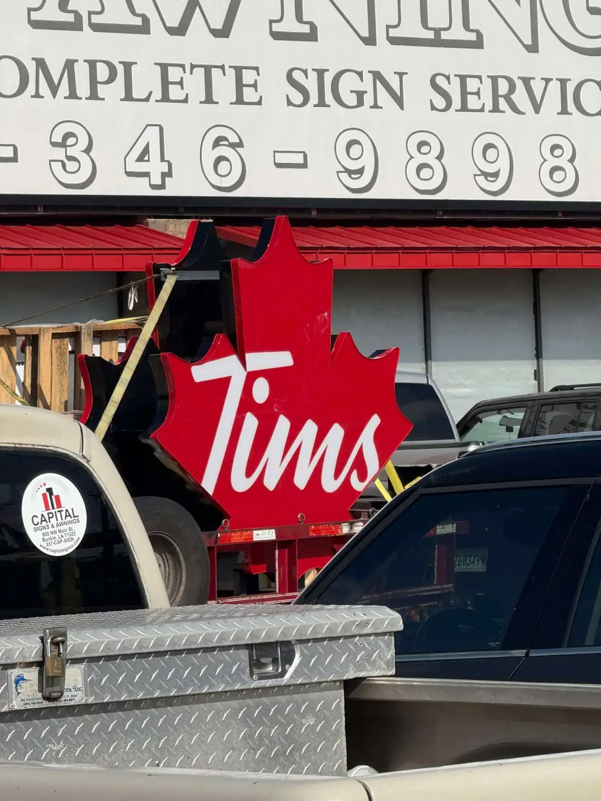 Finished red illuminated maple leaf sign panel fabricated by JG's, staged on a trailer outside the sign shop in Bunkie, Louisiana