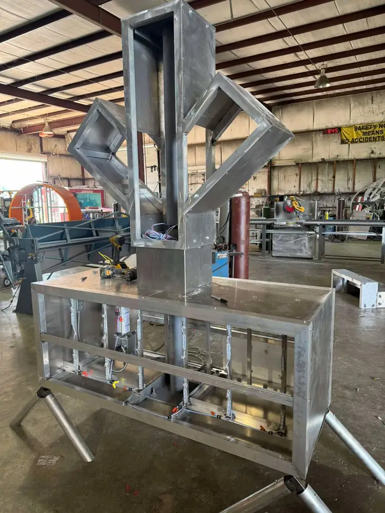 Aluminum sign cabinet with a dimensional logo frame and internal wiring under construction on a rolling stand
