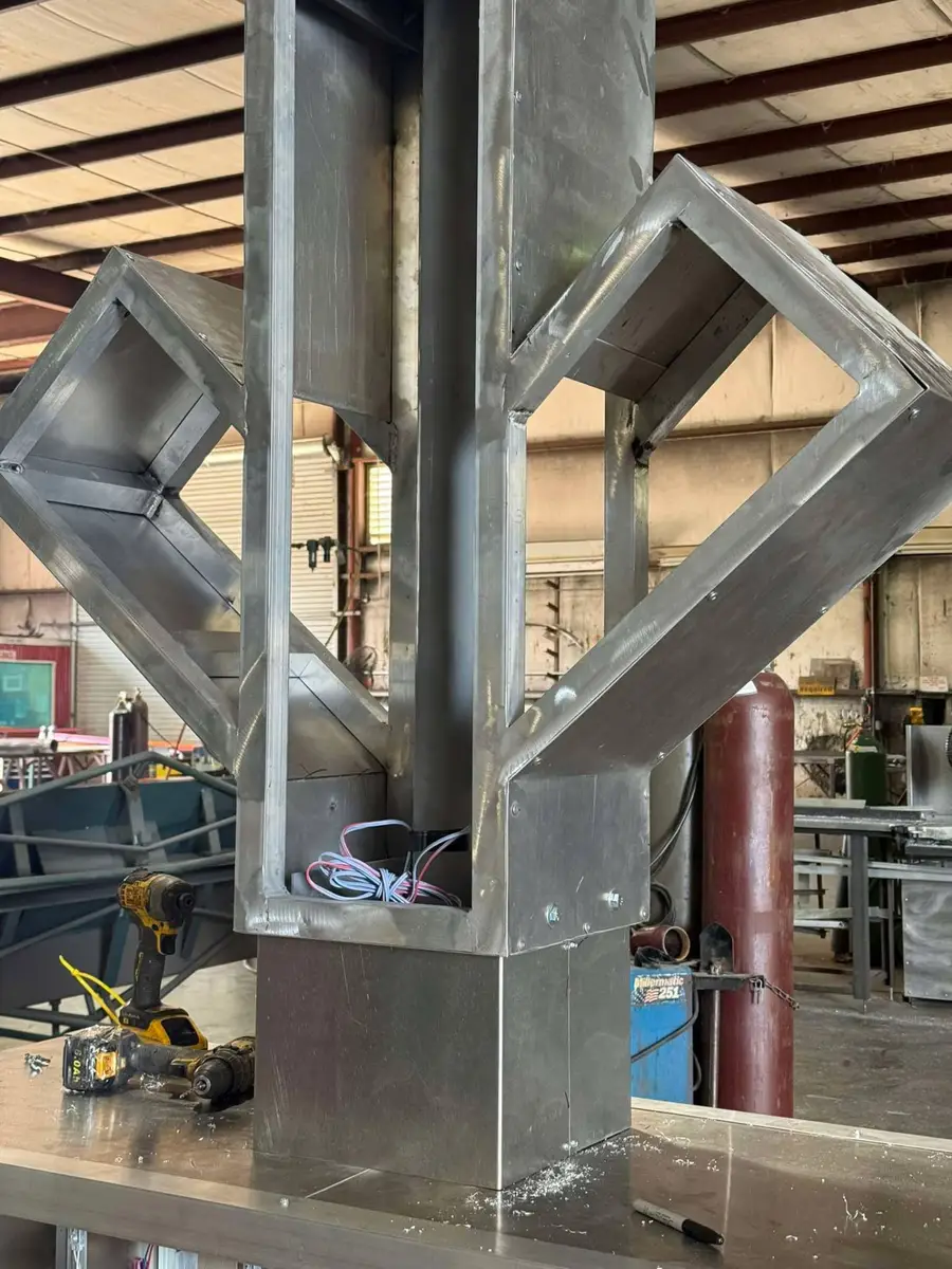 Welded aluminum returns and mitered corners on a dimensional logo sign frame with LED wiring routed inside