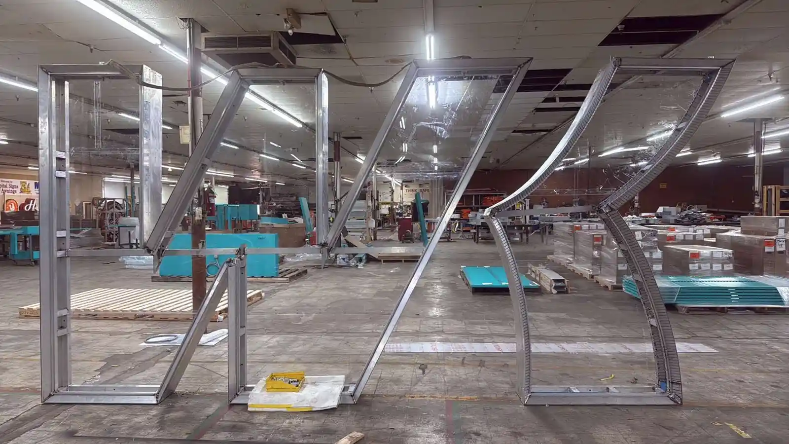Tall aluminum sign letter frames standing full height inside the fabrication shop in Avoyelles Parish