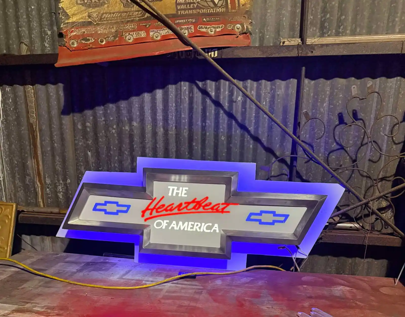 Completed halo-lit bowtie sign powered up and displayed on a workbench in the Bunkie shop