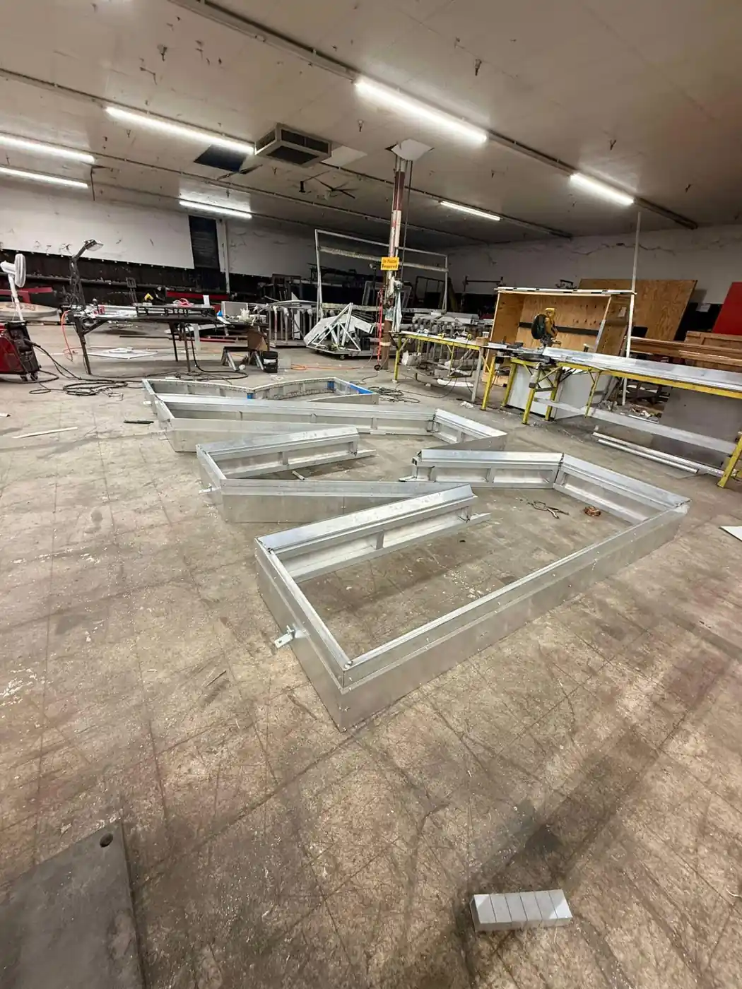 Large welded aluminum sign letter frames staged on the fabrication floor in Bunkie, Louisiana