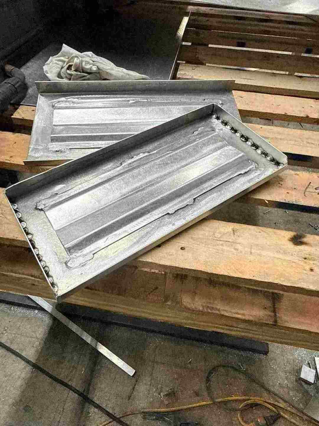 Two custom aluminum dry box hatch pans with welded seams built for a boat deck in Louisiana