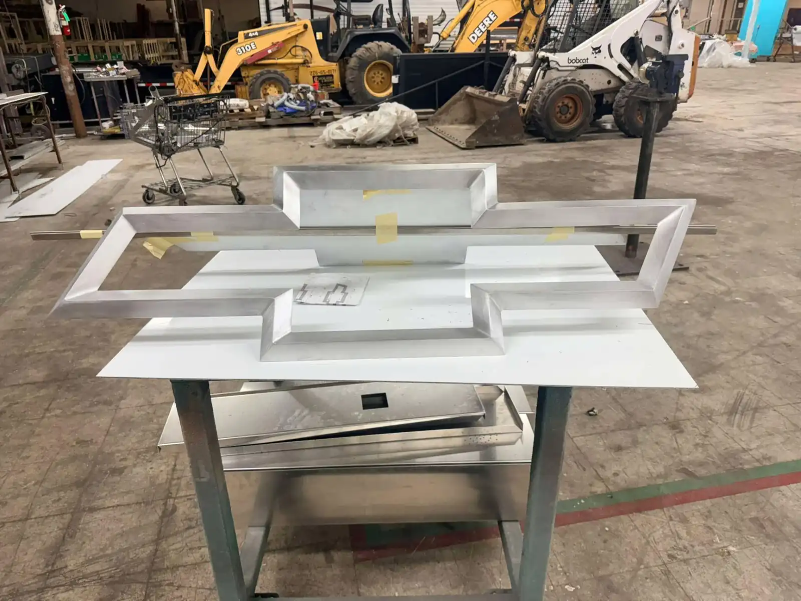 Aluminum bowtie sign returns fitted over a white face panel during assembly in the Bunkie shop