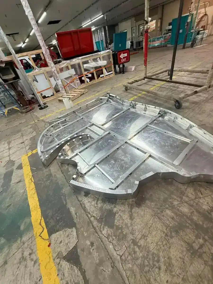 Formed aluminum logo sign pan with welded ribs and notched returns resting on the shop floor